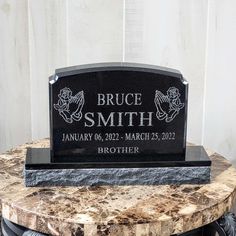 a black headstone with the name bruce smith on it sitting on top of a table