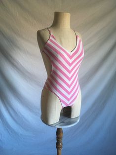 vintage 1980s swimsuit Gottex Jrs. 45% cotton, 45% polyester, 10% lycra white and pink chevron striped plunge back sides of body are partly exposed cross back straps lined panty/bust good vintage condition light wear- light stains-see photos  labeled size is outdated, smaller- like a xs, see below measures, lying flat, chest-12" to 17" stretched waist-9 1/4" (sides are open) hip-13" to 18 1/2" stretched panty width-2 1/2" length-25" to 30" Sleeveless Cotton Swimwear, Fitted Striped Swimwear For Poolside, Fitted Striped Swimwear For Summer, Pink Cotton Swimwear For The Pool, Fitted Striped Swimwear For Spring, Striped Lined Swimwear For Summer, Summer Striped Fitted Swimwear, Fitted Striped Summer Swimwear, Spring Striped Cotton Swimwear