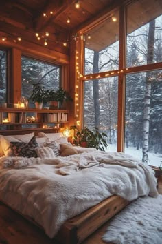 a bed in a room with lots of windows and lights hanging from the ceiling above it