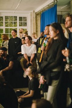 a group of people sitting and standing in a room