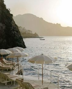 many umbrellas and chairs are on the beach