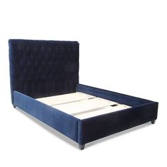 a blue velvet bed frame with white sheets