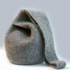 a gray felt bag sitting on top of a white table next to a brown object