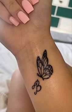 a woman's arm with a butterfly tattoo on the left side of her wrist