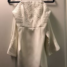 a white dress hanging on a coat rack