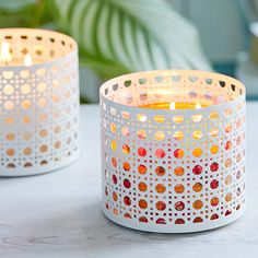 two white candles sitting next to each other on a table