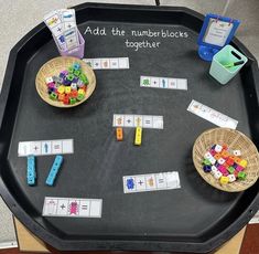 a blackboard with numbers on it and two baskets filled with legos next to each other