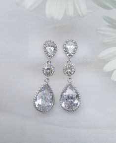 Classic Tear Drop Cubic Zirconia Bridal Earrings that will match easily with any style of Wedding Gown! The high quality Cubic Zirconia sparkles from every angle. I designed these stunning Tear Drop Earrings with good quality Cubic Zirconia. The Pear shaped CZ Earring Posts have a silver plate setting and Sterling Silver Ear Posts. The Tear Drop Cubic Zirconia Pendant is set in a silver plate setting and sparkles like Diamonds! They make a wonderful addition to any woman's jewelry collection. Th Sparkling Linear Drop Earrings For Wedding, Silver Sparkling Teardrop Earrings For Wedding, Wedding Clip-on Earrings In Diamond White Cubic Zirconia, Silver Teardrop Earrings With Sparkling Stones For Wedding, Wedding Silver Sparkling Teardrop Earrings, Wedding Sparkling Silver Teardrop Earrings, Diamond White Drop Earrings For Wedding, Classic Diamond White Linear Earrings For Wedding, Classic Teardrop Linear Earrings For Wedding