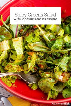 a red bowl filled with lettuce and other green salads on top of a table