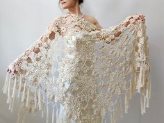 a woman wearing a white crochet shawl