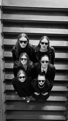 six people wearing sunglasses are standing on the stairs