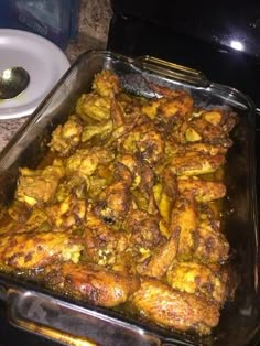 a casserole dish with meat and vegetables in it on a counter top next to an oven