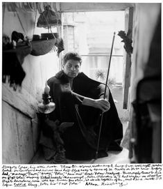 black and white photograph of a man sitting on the floor in front of a window