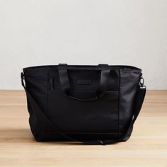 Part of our exclusive West Elm Travel Collection, this lightweight, streamlined weekender is perfectly sized for short solo trips or weekends away. It has a removable shoulder strap and secures to our Hardside Spinner Luggage (sold separately) to make traveling in style easy. 23"w x 7.25"d x 14.5"h. Nylon (Black, Copper, Olive, Teal, Yellow) or polyester (Heather Gray, Heather Blush) body. Bicast leather handles. Removable, adjustable shoulder strap. Large padded pocket for laptops or tablets. Z West Elm Collection, Solo Trips, Hardside Spinner Luggage, City Backpack, Gift Totes, Spinner Luggage, Teal Yellow, Travel Collection, Travel Tote