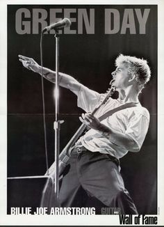 an advertisement for green day with a man holding a guitar and singing into a microphone