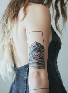 a woman with a mountain tattoo on her arm