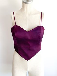 Delicious, regal dark violet fitted bustier with straps. Side zips. A rare, nearly perfect thing of beauty. Made in Italy. Fabric: Wool with acetate liningLabel: Moschino CoutureFit: SEra: 1990’s Measurements: Bust 34"Under bust 27"Between straps 9" Length (side) 7"Strap drop (shoulder to top) 6" Condition: Very good. One strap is twisted (i.e. doesn't lay flat) and one small hole in front outer covering (see photo). Luxury Bustier With Straps, Luxury Bustier Top With Straps, Luxury Satin Finish Bustier Corset, Luxury Fitted Bustier Crop Top, Moschino Crop Top, Dark Violet, Moschino Couture, Fabric Wool, Galaxy Wallpaper