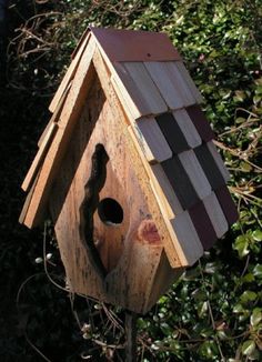 a bird house made out of wood with a hole in the roof