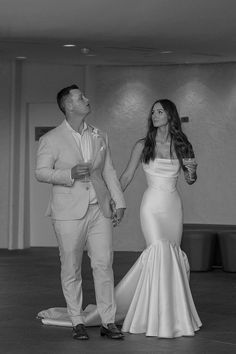 a man and woman standing next to each other on a dance floor in formal wear