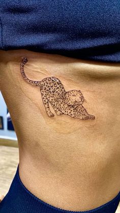 a woman's stomach with a tattoo of a cheetah on the side