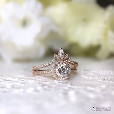 a close up of a diamond ring with flowers in the background