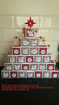 a christmas tree made out of calendars on a table with a red star above it