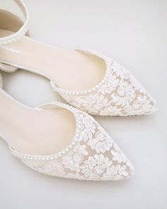 white wedding shoes with pearls and lace on the toes are ready to be put on