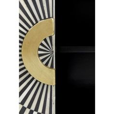 a black and white striped wall with a gold letter on it's front door