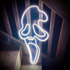 a neon sign that is on the side of a wooden wall in front of a stair case