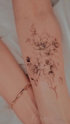 a woman's legs with flowers tattooed on them