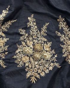 an embroidered black cloth with gold flowers and leaves