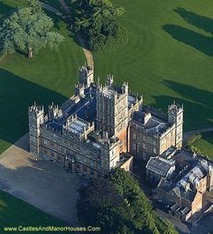 an aerial view of a large building in the middle of a green field with trees