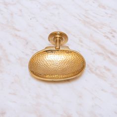 a close up of a gold colored object on a marble surface