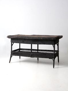 a wicker coffee table with two trays underneath it on a white background,