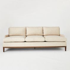 a white couch sitting on top of a wooden frame