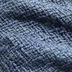 a close up view of the texture of a blue and gray blanket with green accents