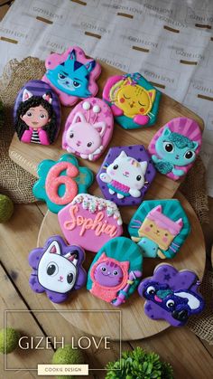 there are many decorated cookies on the plate with name written in it and pictures of animals