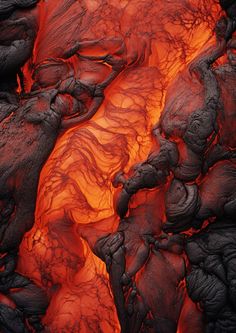 an aerial view of lava in the ocean with red light coming from it's surface