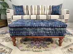 a blue and white couch sitting on top of a rug