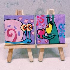 two paintings on easels with one holding a heart and the other looking at it