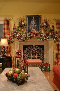 a living room decorated for christmas with red and green decorations on the fireplace mantel