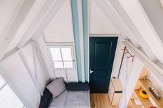 an aerial view of a tiny room with a couch and bookshelf in the corner