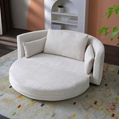 a white round chair sitting on top of a rug next to a potted plant