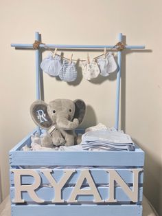 an elephant sitting on top of a blue box with clothes hanging from it's sides