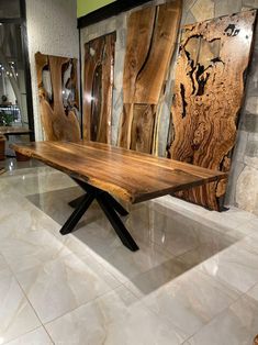 a wooden table sitting on top of a white tile floor next to wood art pieces