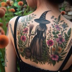 the back of a woman's shoulder with flowers and a witch holding a broom