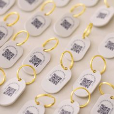 many tags are attached to gold colored metal rings with qr code printed on them