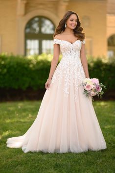 a woman in a wedding dress standing on the grass