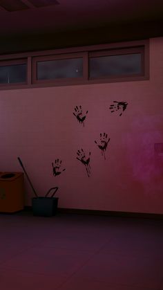 a pink room with black hand prints on the wall and trash can next to it