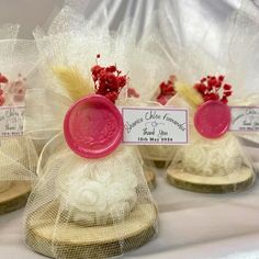 three small hats with tags on them sitting on a white table cloth covered tablecloth